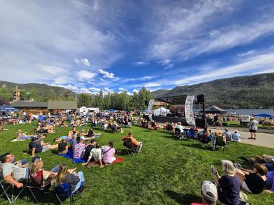 Spectators sprawled on sunny lawn during Troublesome Fest