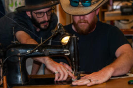 Men working with a leather sewing machine during a Rocky Mountain Folk School workshop