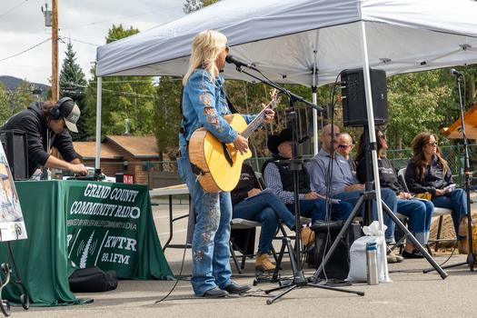 Local artist Peggy Mann plays a song on the guitar